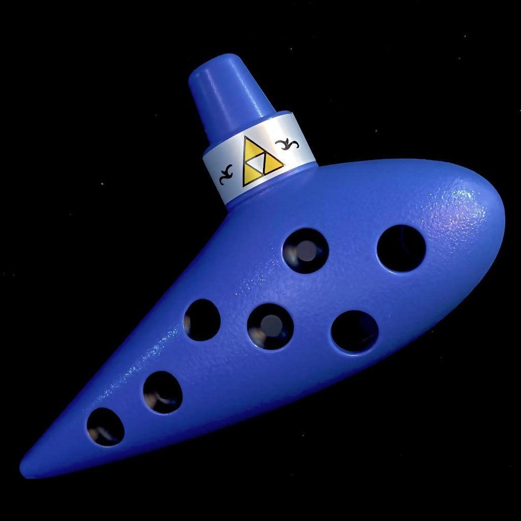 another angle of a blue plastic oot 7-hole alto c ocarina replica from Zelda on a black background