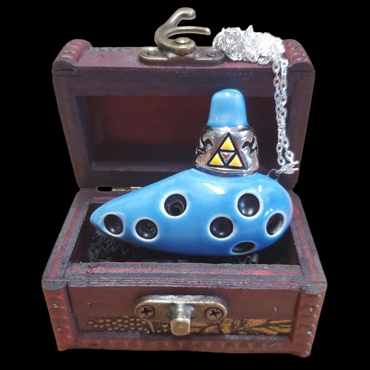 Blue zelda ocarina of time mini pendant with Triforce symbol in a wooden treasure chest 