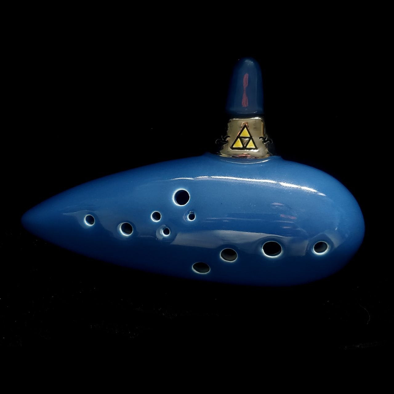 blue 12-hole tenor G oot Zelda : ocarina of time replica with a black background